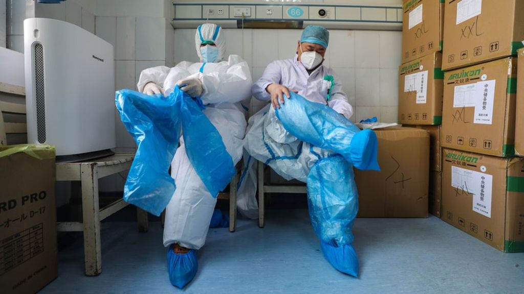 عاملان طبيان يرتديان ملابس واقية في مستشفى لعلاج مرضى فيروس كورونا في ووهان بالصين