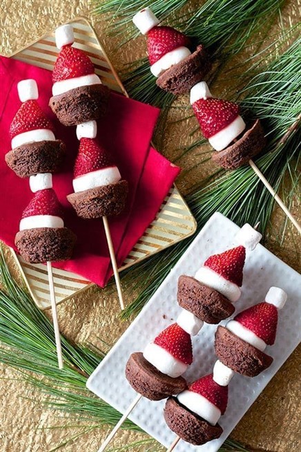 لتقديم الحلوى على المائدة اصنعي اشكال قبعة بابا نويل من كيك الشوكولاته والفراولة والمارشميلو وعلّقيها على العيدان الخشبية.