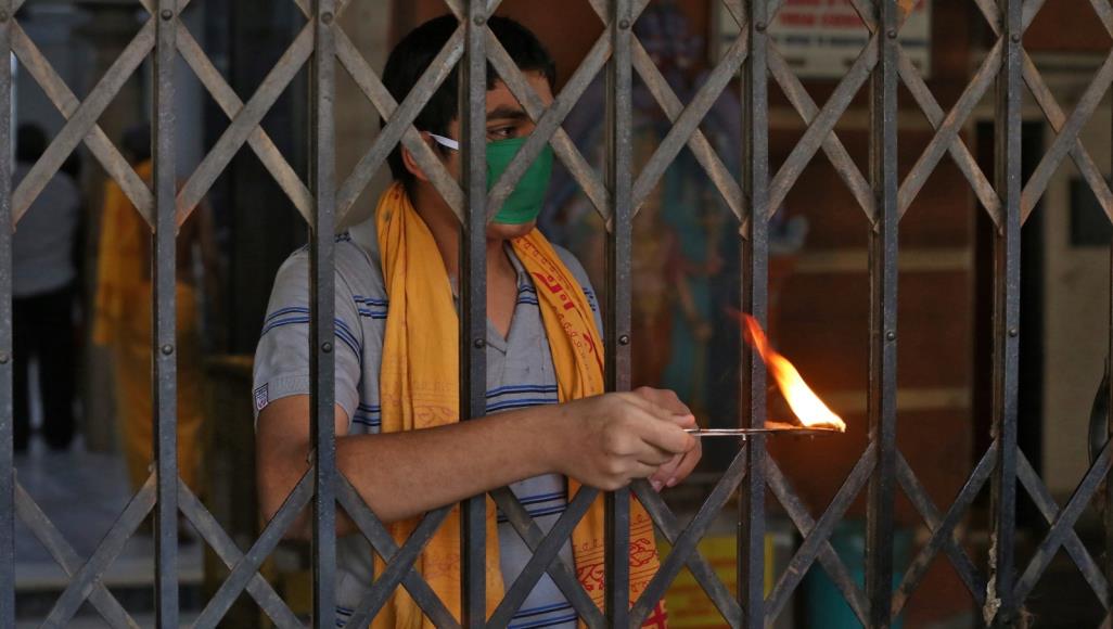 كاهن هندوسي يؤدي طقوسًا بأحد معابد نيودلهي خلال إغلاق لمدة 21 يومًا بالدولة لإبطاء انتشار  الفيروس (رويترز)
