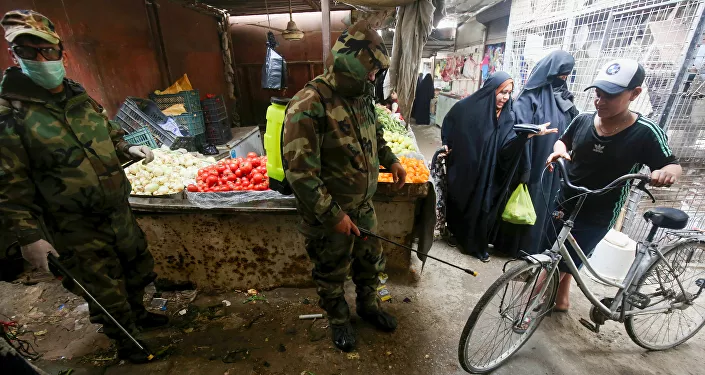 ضابط الدفاع المدني العراقي يقوم بتطهير الأماكن التجارية في ضواحي بغداد، في ظل انتشار فيروس كورونا في العراق 28  مارس 2020