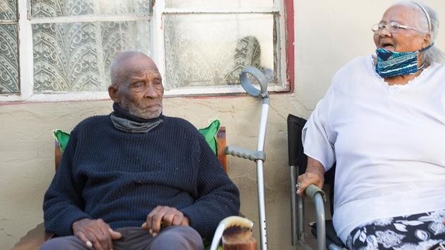 Fredie Blom (kiri) ditemani istrinya, Jeanette (86) ketika merayakan ulang tahun ke 116 di rumahnya di Delft, dekat Cape Town, 8 Mei 2020. Menurut 'Oupa' (kakek) Fredie dan kartu identitasnya, ia lahir pada tahun 1904 yang menjadikannya salah satu pria tertua di dunia. (RODGER BOSCH/AFP)