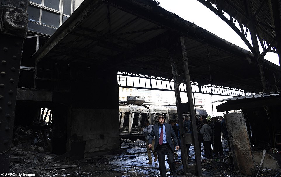 Onlookers gather at the scene of a fiery train crash at the Egyptian capital Cairo's main railway station