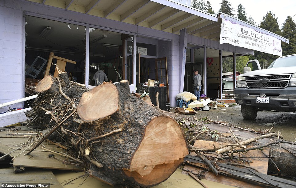A log rests at a destroyed shop along River Road as flood waters from the Russian River continue to recede in Guerneville