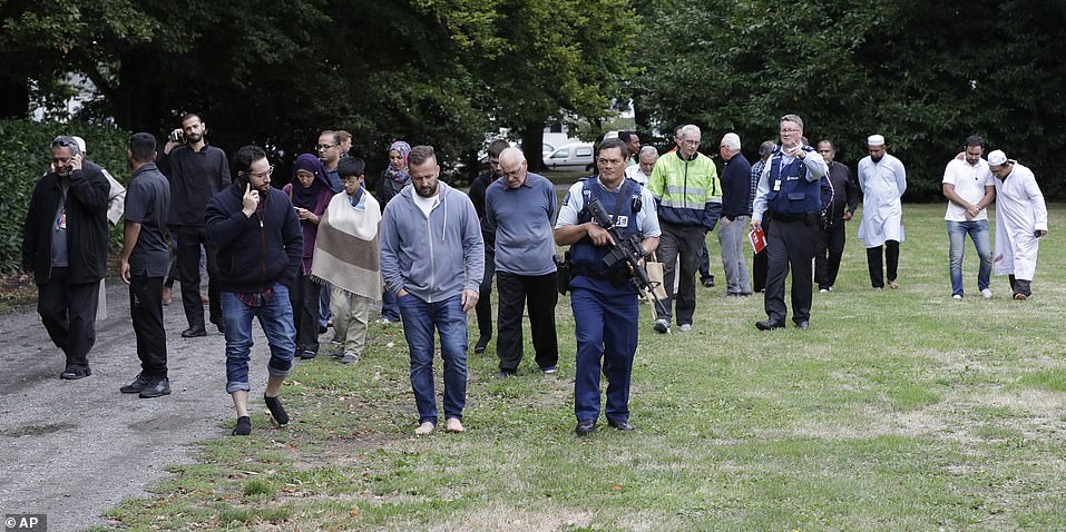 Police escort distraught witnesses away from a mosque in central Christchurch following the massacre. A 28-year-old man has been charged with murder