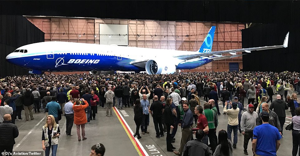 Boeing employees gather around the first fully assembled 777X aircraft at the plane manufacturer's plant near Seattle. The jet was unveiled at a low key ceremony attended by Boeing staff only