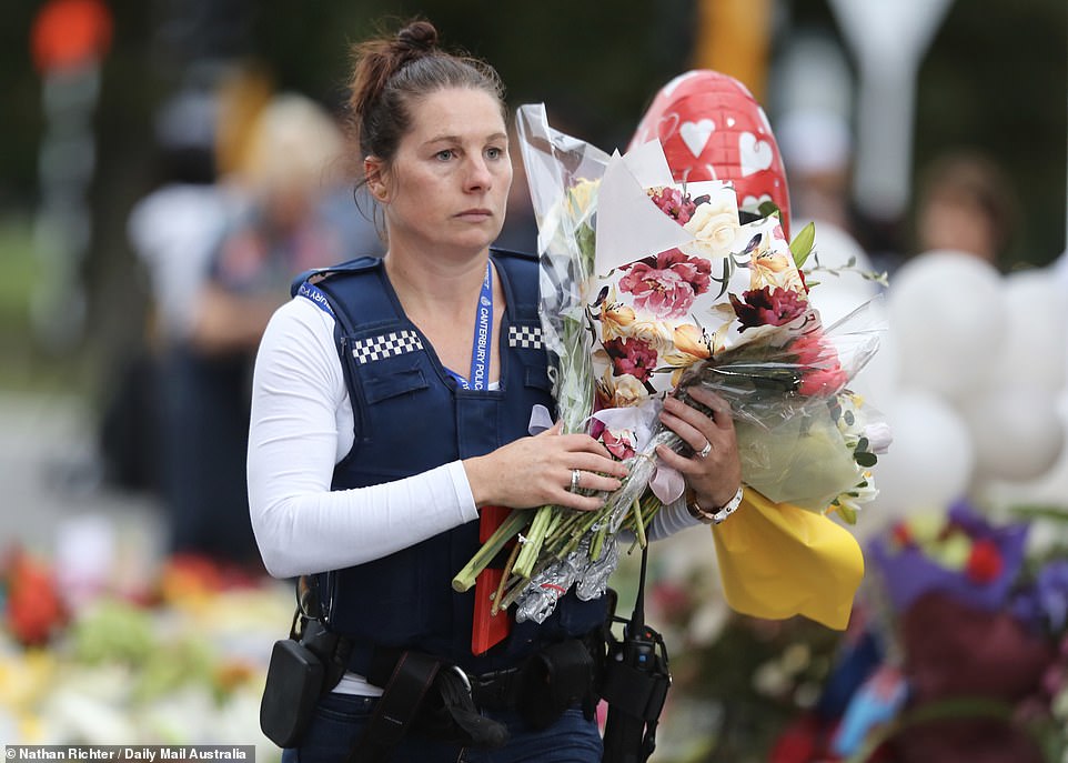 Makeshift vigils were underway in Christchurch on Saturday night, with one policewoman laying a bunch of flowers