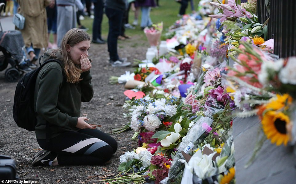 People pay their respect with floral tributes for victims of the mosque attacks. Vigils were underway across New Zealand