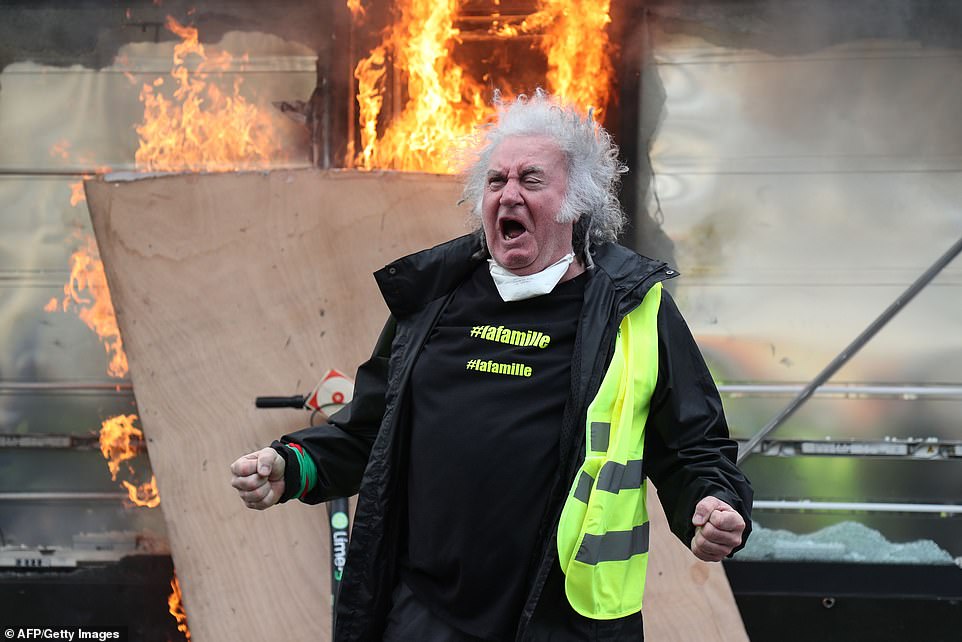 A protester gestured wildly in front of a newsagent which had been set alight
