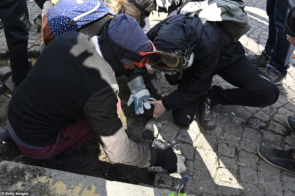 Yellow vests protesters break the rocks on sidewalks during the demonstrations