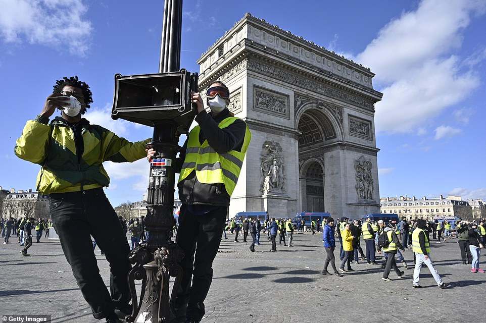 Yellow vests, or Gilets jaunes, protesters stage a demonstration on a lamppost on avenue Champs Elysees