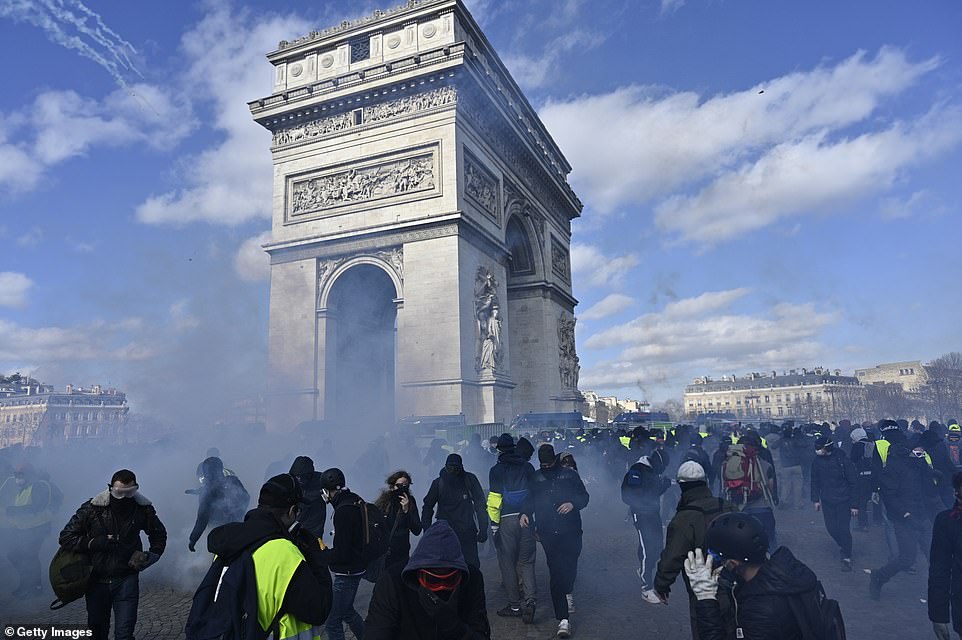 Security forces intervene yellow vest protesters with tear gas during a demonstration on avenue Champs Elysees in Paris