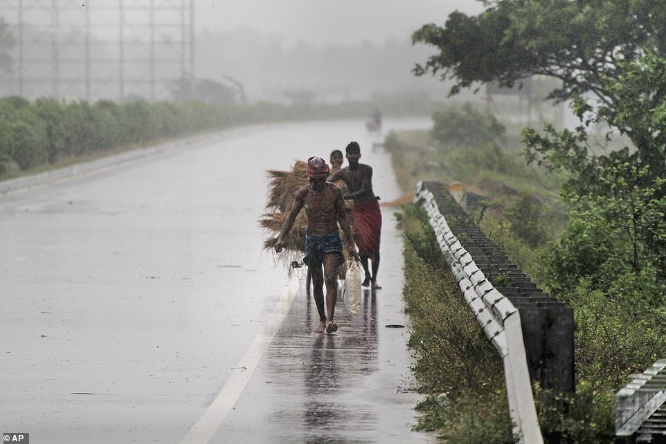 Rush for safety: Villagers look to take cover on a road on the outskirts of Puri as the cyclone hits amid fears it will cause a deadly storm surge