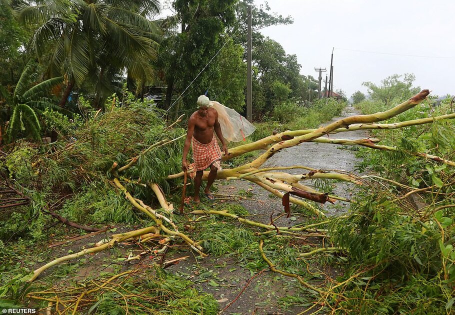 Desolation: A man cuts branches of an uprooted tree following Cyclone Fani in Khordha district in the eastern state of Odisha