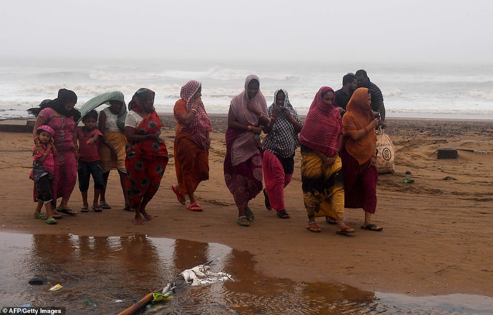Indian residents walk along a beach after Cyclone Fani hits Puri, in the eastern Indian state of Odisha on Friday