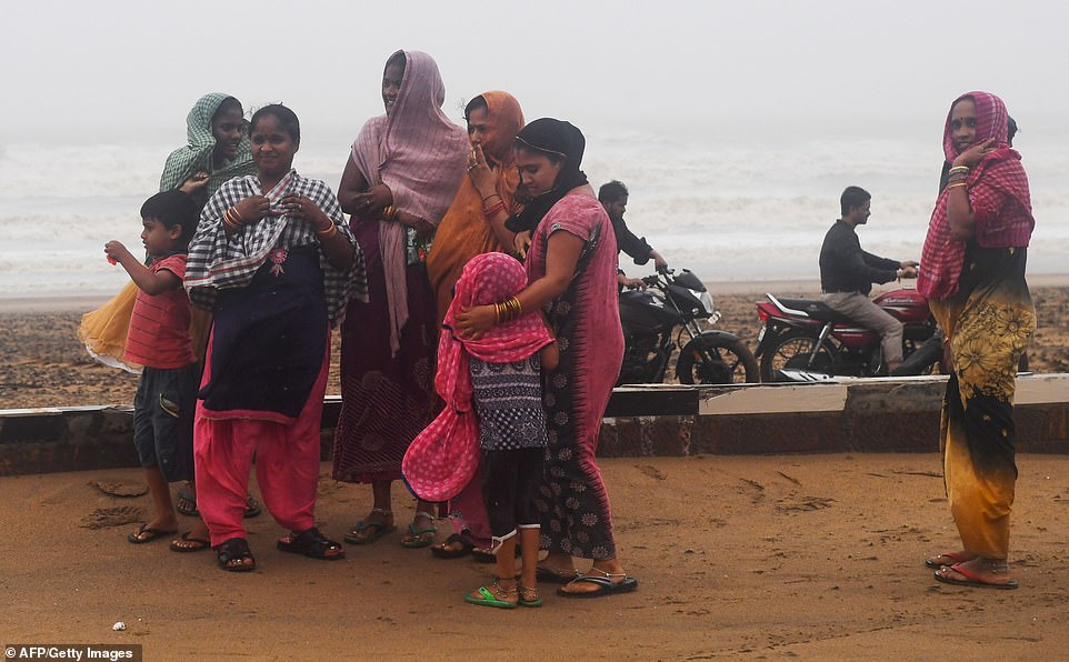 The families stand on a beachfront huddling together after Cyclone Fani landfall in Puri, in the eastern Indian state of Odisha on May 3, 2019