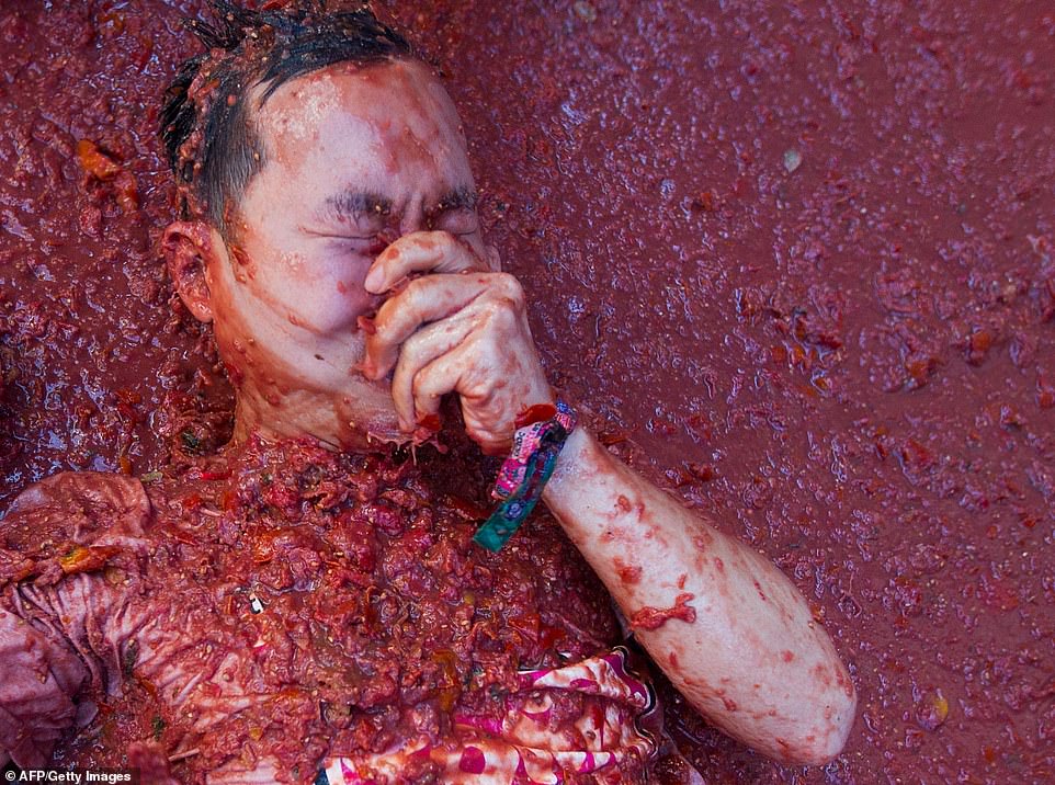 A reveller covered in tomato pulp takes part in the annual "Tomatina" festival in the eastern town of Bunol, on August 28