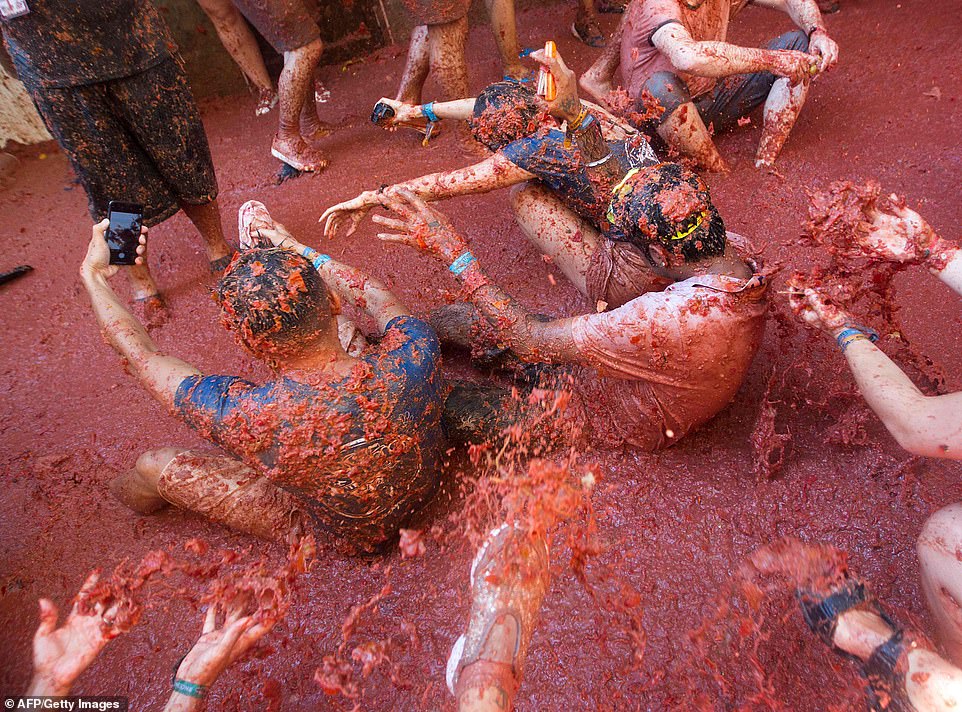 These friends, drenched in tomato pulp, appear to performing some kind of synchronised exercise during the festival today