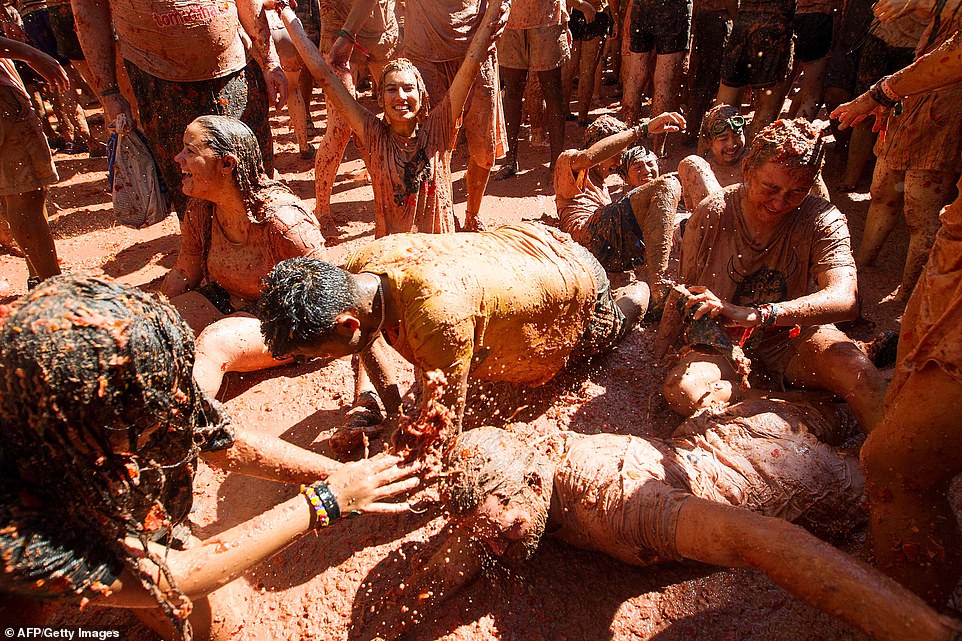 Despite being covered in tomato pulp, this group of revellers seem filled with joy as they take part in the famous local festival