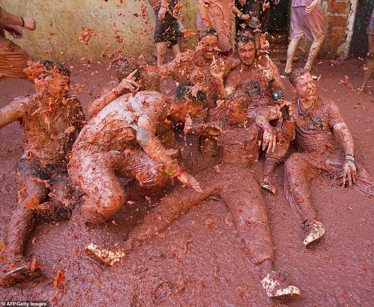 A group of revellers completely covered in tomato pulp take part in the annual "Tomatina" festival in the eastern Spanish town of Buno