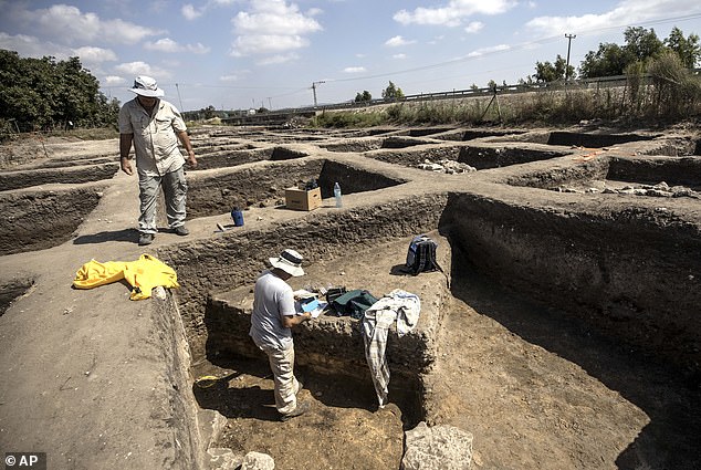 Archaeologists work in a pit at a large, 5,000-year-old city in northern Israel
