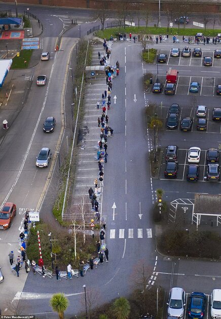 Police were yesterday forced to step in to stop selfish stockpilers from barging past pensioners and ransacking supermarket shelves. Pictured are hundreds of shoppers queueing a Tesco this morning at 6am
