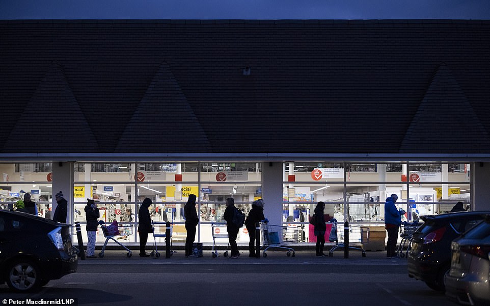 At 5.40am shoppers wait for a Tesco superstore in New Malden, south London, to open as the spread of the Coronavirus continues in the capital