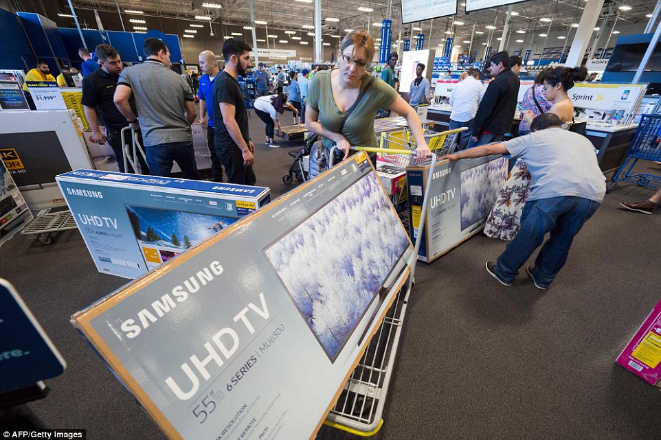 CALIFORNIA: A woman tries to maneuver a 55in television out of Best Buy in Burbank 