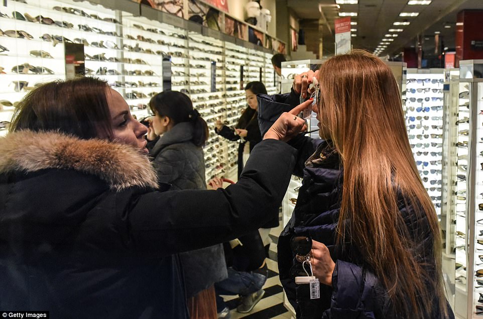 MANHATTAN: Two women try on sunglasses at Century 21 in downtown Manhattan in New York on Black Friday