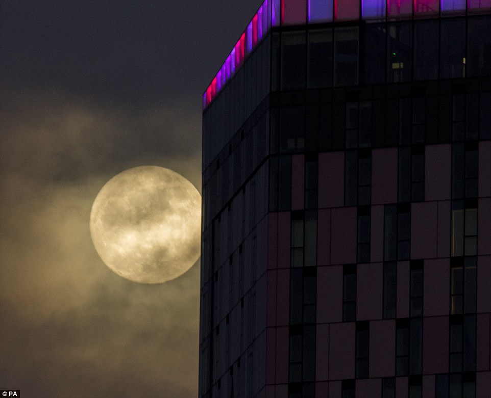 The incredible celestial event turns the moon a reddish hue as the lunar eclipse happens. Pictured is the super moon rising behind the Saffron Square building in Croydon ahead of this 'unusual' event