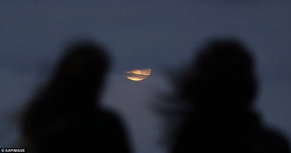 The darker part of Earth's shadow will begin to blanket part of the moon with a reddish tint at 6:48 am EST (11:48 GMT), but the moon will set less than a half-hour later. Pictured is the moon rising near Bondi beach hours before the celestial event