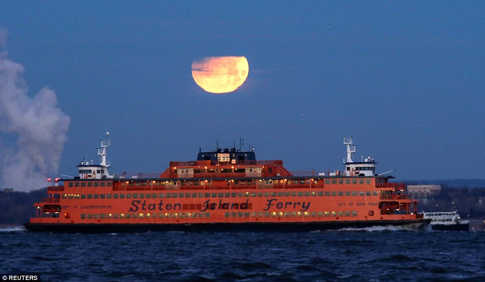 The moon is pictured behind the Staten Island Ferry, seen from Brooklyn. For people viewing the event from New York the moon entered the outer part of Earth's shadow at 5:51 am (10:51 GMT)
