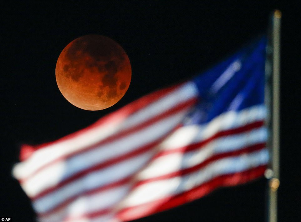 A rare occurrence called a 'Super Blue Blood Moon' is seen behind the U.S. flag at Santa Monica Beach in Los Angeles