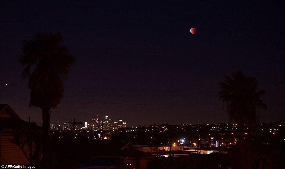 A Super Blue Blood Moon hovers over Los Angeles, California in the early hours of January 31, 2018, during an event not seen since 1866 when three fairly common lunar happenings occur at the same time