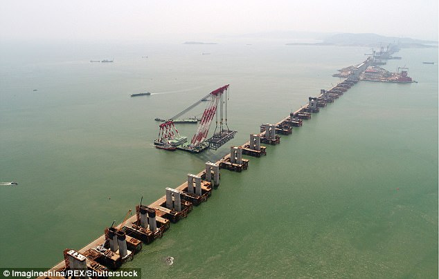 Mission impossible: Chinese workers are building a high-speed railway bridge (pictured) off the coast of south-east China, which is a 'no-go zone' for bridge builders due to high winds