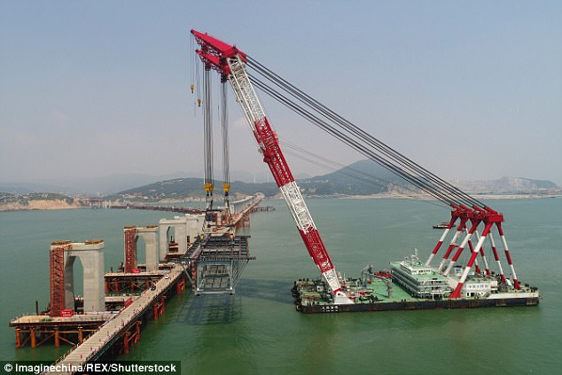 Monster machines: China has built a team of impressive drillships and cranes for the bridge. One of then, the 'Bridge Seagull' crane vessel, is pictured lifting a 1,350-tonne steel beam