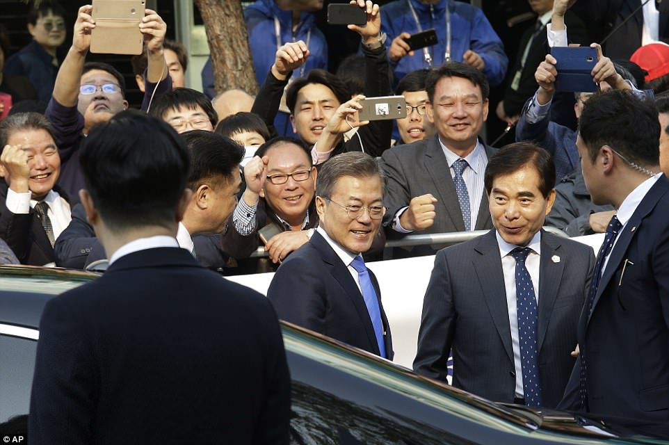 Moon on Friday briefly stepped out of his black limousine and cheerfully shook hands with hundreds of supporters who waved white South Korean flags and raised banners with messages including "Please Achieve Successful Denuclearization'