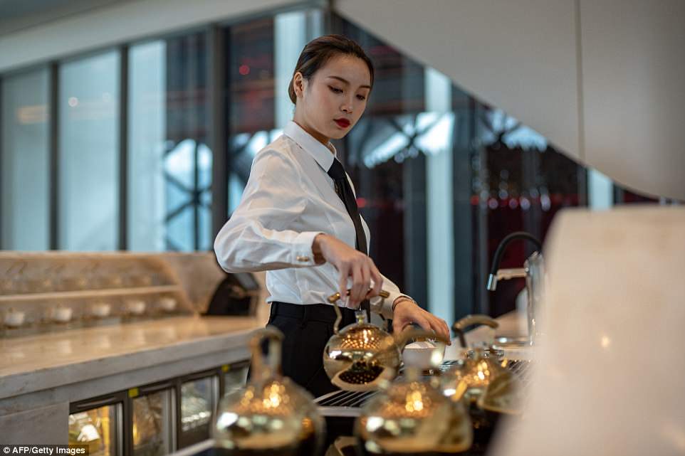 A waitress prepares tea at a restaurant in the 'Morpheus' resort. Extravagant duplex villas with their own in-room gym and massage quarters are located on the top floors of Morpheus for VIPs, along with a gaming area exclusively for these residents