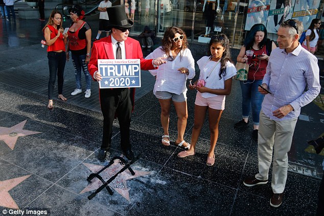 Gregg Donovan, a British-born actor living in Santa Monica, showed up later on Wednesday to 'protect' what remains at this moment of Trump's demolished star, holding a 'Trump 2020' sign