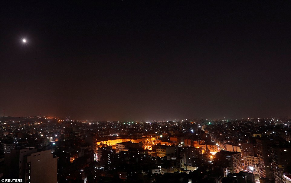 Blood moon from afar: The 'Super Red Blood Moon' is pictured from a distance above the glittering lights of Cairo, Egypt 