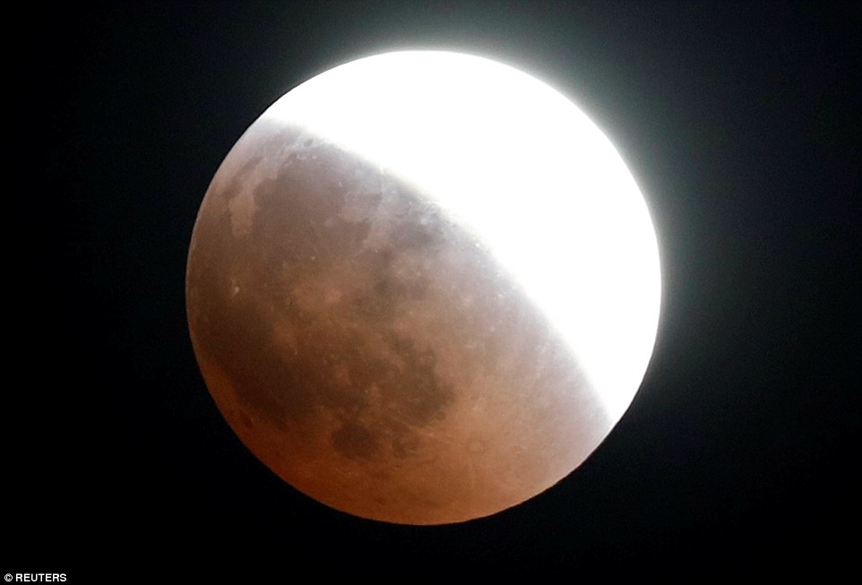 The Blood Moon begins to take hold across the night's sky in Cairo, Egypt this evening as stargazers watch in awe 