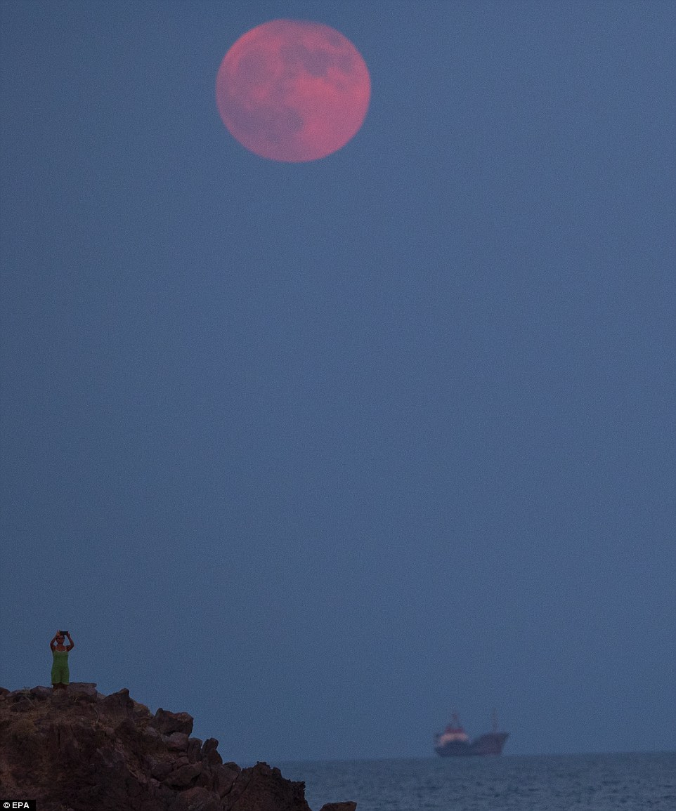 It's A woman is pictured watching the full Blood Moon rise in Sivrice village, Canakkale city, on the Aegean coast of Turkey