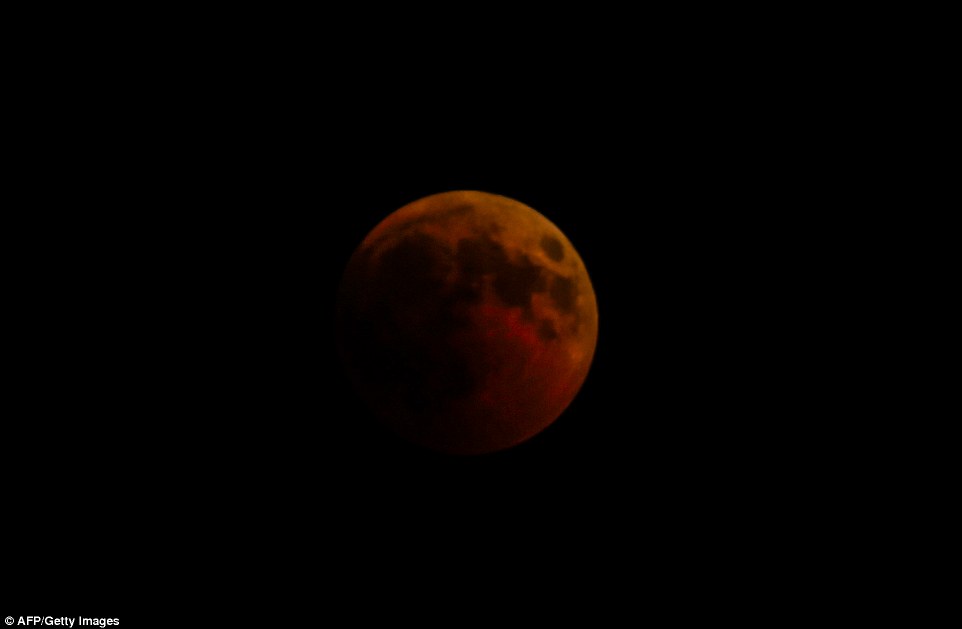 Pictures show the crimson of the moon across the night's sky in Gaza as the longest lunar eclipse this century takes place