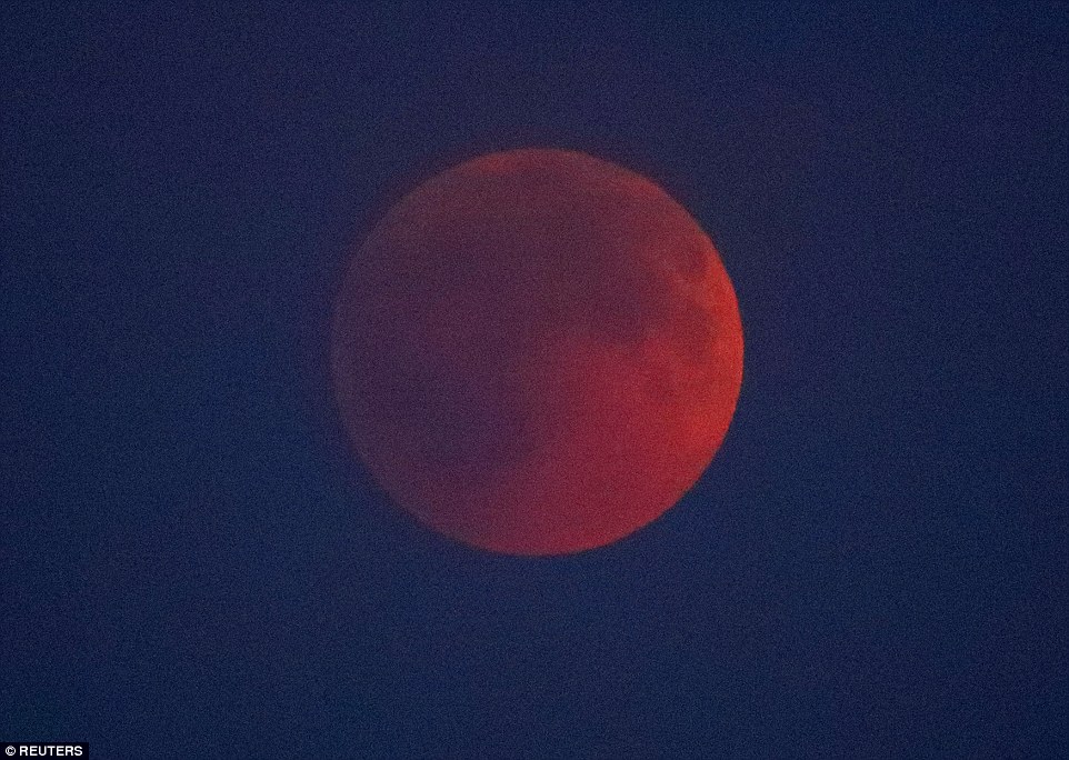 Berlin: The Blood Moon is pictured in a spectacular crimson against the night's sky above the German capital this evening 