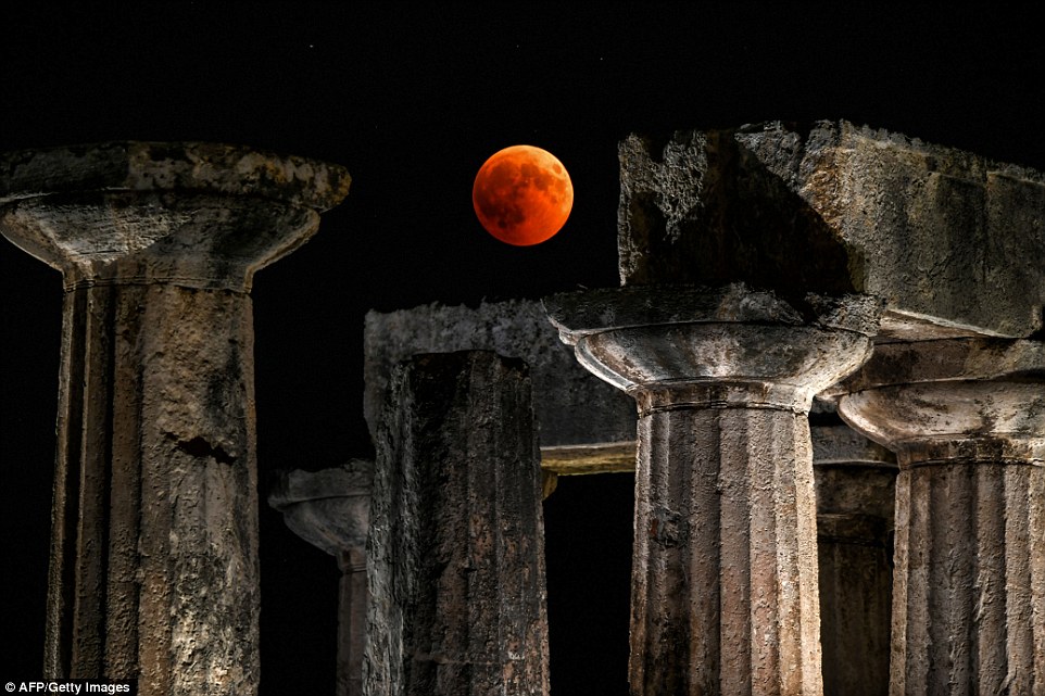 A picture shows the full moon during the 'Blood Moon' eclipse over the temple of Apollo in Corinth, Greece tonight 