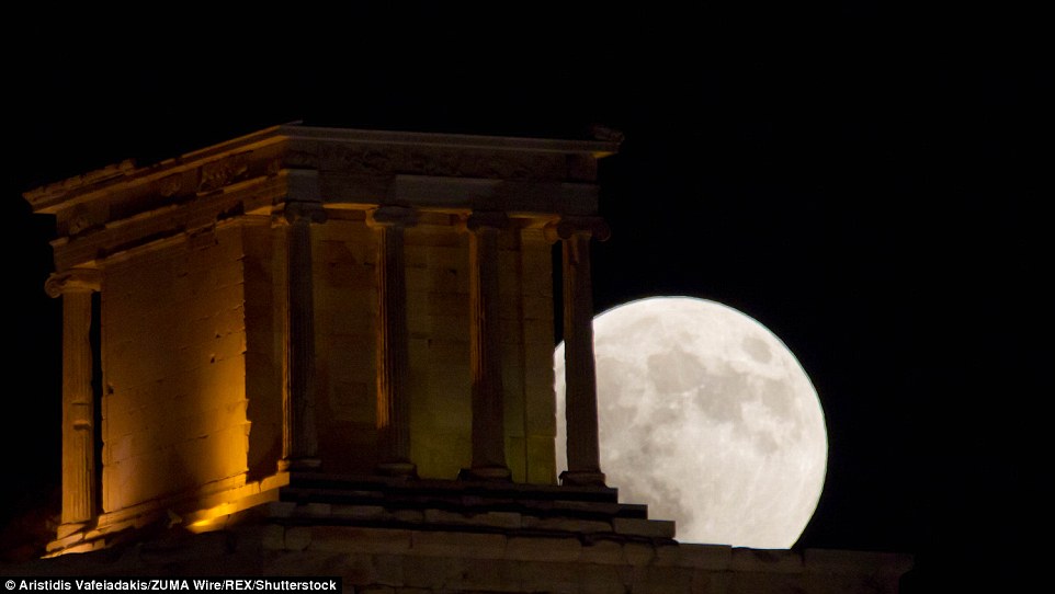 Full 'Blood Moon' rises over the ancient Temple of Athena Nike in Acropolis, Greece this evening during the lunar eclipse 