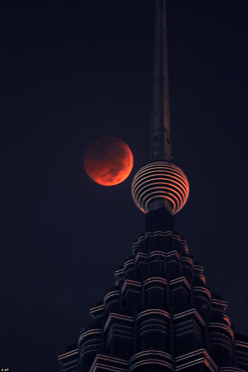 A full Blood Moon sets over Petronas Twin Tower during the complete lunar eclipse in Kuala Lumpur, Malaysia on Saturday