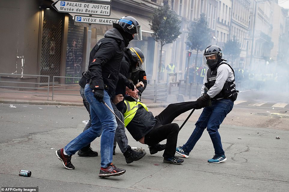 A yellow vest anti-government protester is detained by security personnel in Rouen today. Protestors took a break over Christmas and on New Year's Day a defiant Emmanuel Macron used his New Year's Eve address to hit out at the 'hateful mob' on the fringes of the Yellow Vest movement