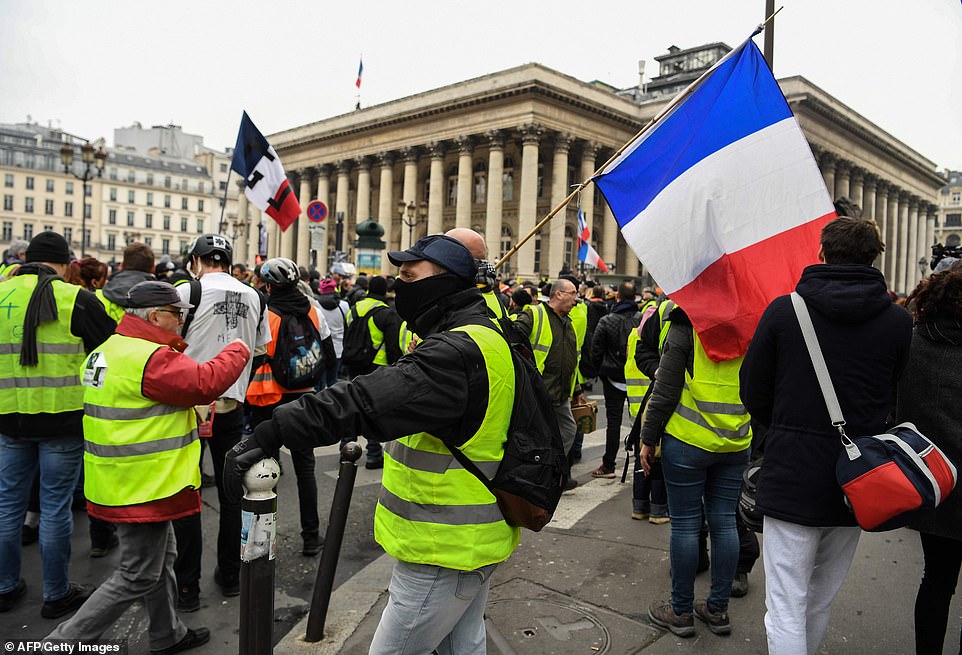 Crisis-ridden Mr Macron has not only climbed down on imposing green surcharges, but increased the national minimum wage by seven per sent, and scrapped tax on bonuses. Pictured are protestors in Paris today