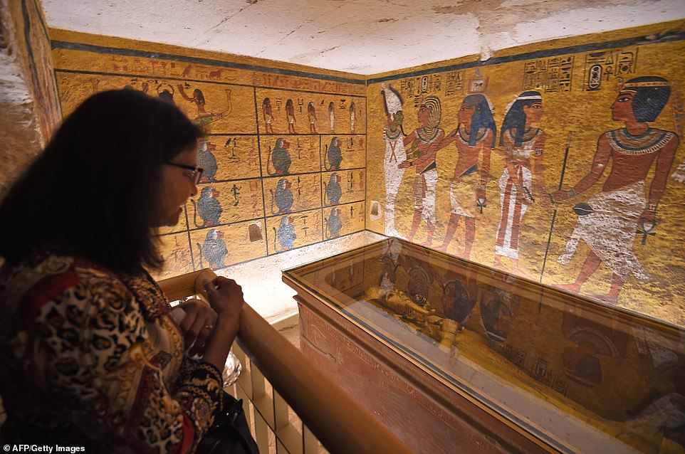 A woman looks at the golden sarcophagus of the 18th dynasty Pharaoh Tutankhamun  displayed in his burial chamber