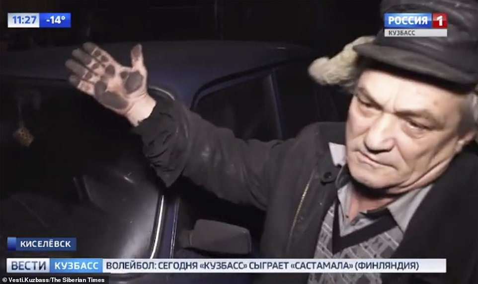A man inÂ Kemerovo shows a TV camera the dirty snow left on his car after the coal plant pollution filled the region and was left on buildings, roads and vehicles
